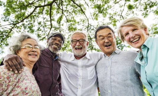 Group of senior adults smiling at camera and living active retirement lifestyle