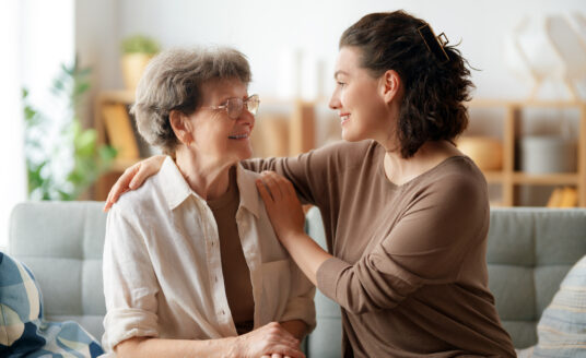 Young woman practicing the best senior care tips while caring for elderly woman