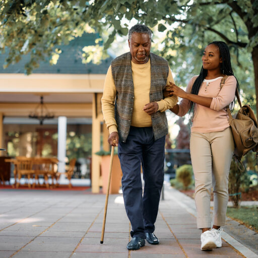 Young woman assisting senior man walking with cane, a way to show respect for the elderly